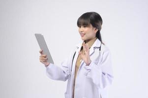 jovem médica com estetoscópio sobre fundo branco foto