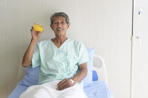 um homem paciente sênior asiático está mostrando cartão de crédito no hospital foto