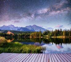 fantástico céu estrelado e a via láctea sobre um lago no parque high tatras. Shtrbske Pleso, Eslováquia, Europa foto