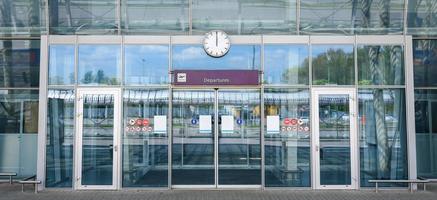 portas de vidro do aeroporto fechado com um sinal de partidas foto