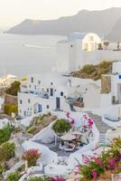 panorama da cidade durante o pôr do sol na vila de oia, santorini. foto