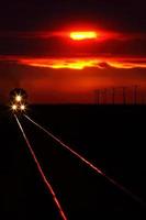 vista panorâmica de um trem se aproximando perto do pôr do sol