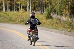 motociclista em uma estrada rural em alberta foto