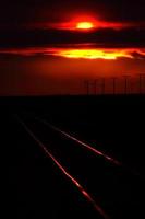 pôr do sol iluminando trilhos de trem na cênica saskatchewan foto