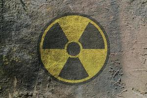sinal de aviso de perigo de radiação retratado em uma parede de concreto foto