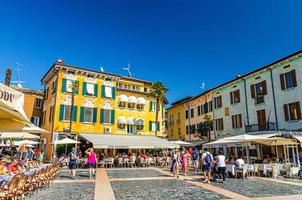 sirmione, itália, 11 de setembro de 2019 centro histórico da cidade com restaurantes de rua e edifícios coloridos multicoloridos foto