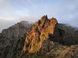 incrível, pôr do sol sobre um pico de montanha em forma de pirâmide. bela luz solar laranja dourada. viajar o mundo. vida nômade. estilo de vida aventureiro. feriados. caminhadas na ilha da madeira, portugal. foto