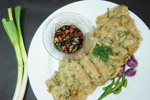 uma comida tradicional javanesa, indonésia, feita de tempeh revestida com farinha e cebolinha semi-frita, é chamada tempe mendoan foto