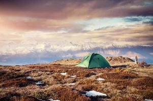 tenda contra o pano de fundo dos picos das montanhas cobertas de neve. a vista das montanhas para o monte ushba mheyer, geórgia. Europa foto