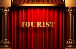 palavra de turista dourada na cortina vermelha foto