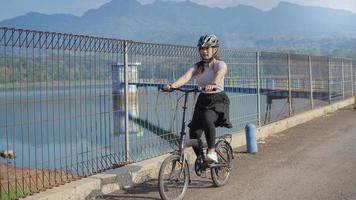 jovem mulher asiática andar de bicicleta no verão