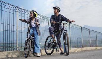 jovem casal asiático descansando depois de andar de bicicleta ir trabalhar foto