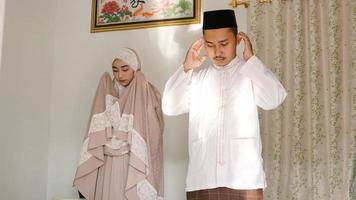 casal asiático rezando juntos em casa foto