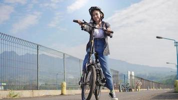 jovem mulher asiática quebrar andar de bicicleta antes de ir trabalhar foto