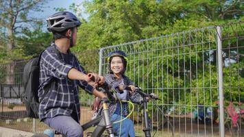 jovem casal asiático anda de bicicleta juntos vão trabalhar foto