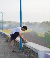 jovem asiático preparar seus sapatos antes de correr de manhã foto