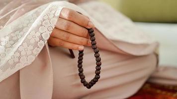 mulher muçulmana segurando contas de oração para dhikr depois de realizar salat foto