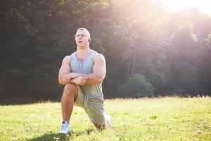 um jovem desportista se preparando para treinamento atlético e fitness ao ar livre. esporte, exercício, fitness, treino. estilo de vida saudável foto