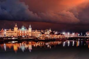 bela noite em amsterdã. iluminação de prédios foto