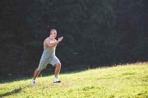 atleta de homem fitness correndo na natureza durante o pôr do sol. pessoa correndo malhando vivendo um estilo de vida ativo treinando cardio no verão em roupas esportivas e sapatos. foto