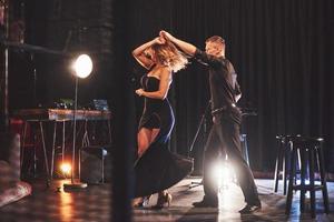 dançarinos habilidosos se apresentando no quarto escuro sob a luz foto
