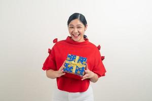 Mulher asiática feliz vestindo uma camisa vermelha com uma caixa de presente disponível para o festival de Natal foto