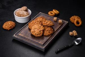 saborosos biscoitos de aveia frescos em um fundo escuro de concreto foto