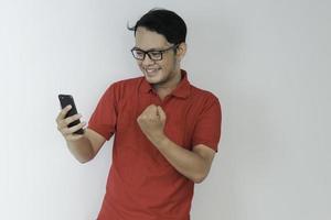 inteligente jovem asiático está feliz e sorrindo ao usar smartphone em fundo de estúdio foto
