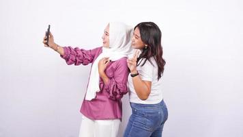 duas mulheres asiáticas fazendo selfies isolado de fundo branco foto