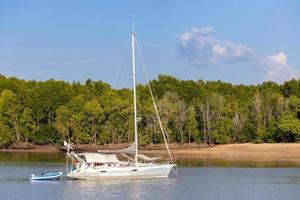 krabi, tailândia - 22 de janeiro de 2020 - bela vista natural de veleiro, barcos, cais, floresta de mangue e montanha khao khanab nam no rio krabi, krabi, tailândia. foto