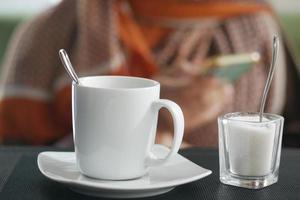 xícara de café de cor branca e açúcar na mesa foto