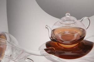 bule de vidro transparente e xícara com chá