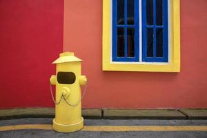 fundo colorido de hidrante amarelo em frente ao prédio da casa foto