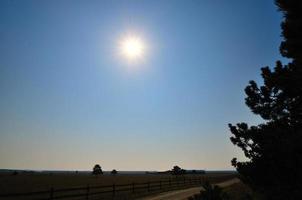 rancho de cavalos e sol no céu foto