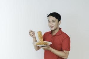 retrato de feliz jovem asiático gosta de macarrão com língua de fora. comendo o conceito de almoço. foto