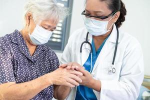 médico asiático usando protetor facial e terno novo normal para verificar o paciente proteger infecção de segurança covid 19 surto de coronavírus na enfermaria do hospital de enfermagem de quarentena. foto