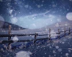 paisagem de inverno. aldeia de montanha nos Cárpatos ucranianos. céu noturno vibrante com estrelas e nebulosa e galáxia. astrofoto do céu profundo foto