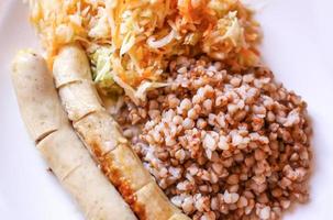 trigo sarraceno com salsichas e salada fresca foto