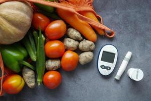 ferramentas de medição para diabéticos e vegetais frescos na mesa foto