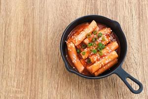 tteokbokki ou topokki, palito de bolo de arroz frito, comida de rua coreana popular com molho picante de gochujang e sementes de gergelim. foto