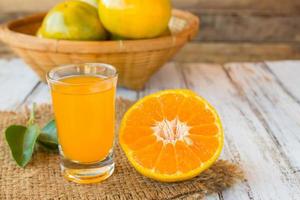 copo de suco de laranja recém-prensado na mesa de madeira
