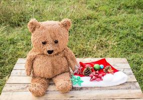 ursinho de pelúcia e decoração de natal na mesa de madeira foto
