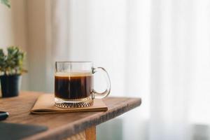 café da manhã, café em uma caneca em uma mesa de madeira com um notebook foto