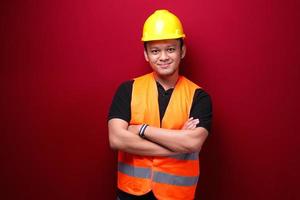 retrato de trabalhador jovem asiático sorridente isolado no vermelho. foto