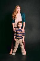 retrato de menino bonitinho elegante com linda mãe em estúdio fotográfico foto