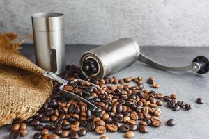 moedor de café de mão e grãos de café em cima da mesa foto