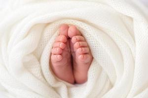 pequenas belas pernas de um bebê recém-nascido nos primeiros dias de vida foto