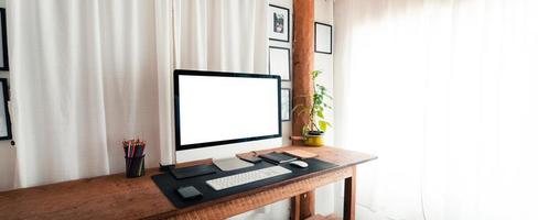 mesa de escritório em casa, tela do computador em uma mesa de madeira em casa foto