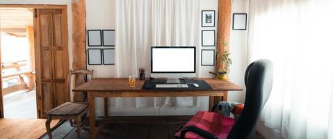 mesa de escritório em casa, tela do computador em uma mesa de madeira em casa foto