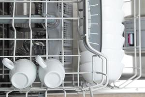 pratos brancos na máquina de lavar louça. lição de casa com conceito de máquina de lavar louça foto